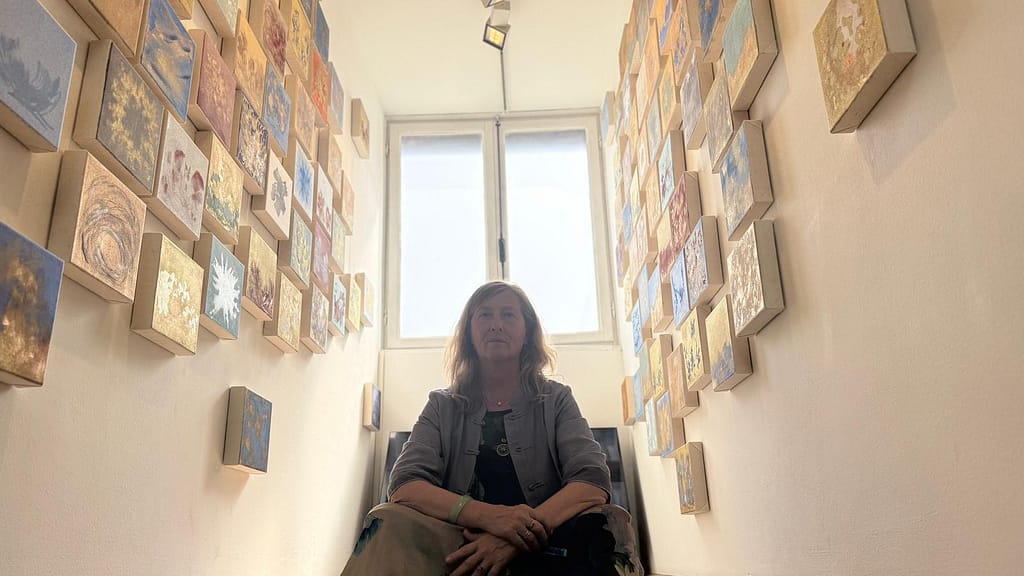 Barbara Duran nello spazio espositivo di Anima Mundi a Palazzo Mora, circondata dalle tele dei Controsortilegi